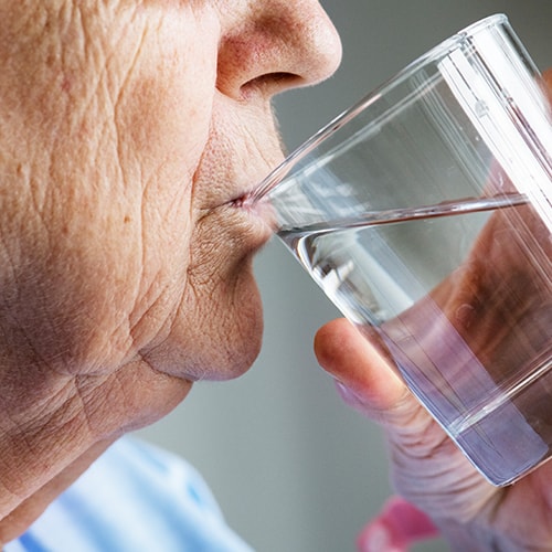 קשיש שותה מים למניעת מחלות בחורף